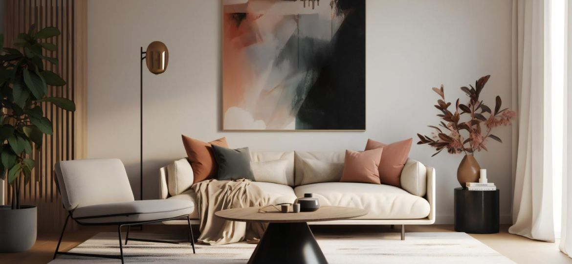A living room with a double white couch covered in pillows with earthy tones, a white rug, and a large painting.